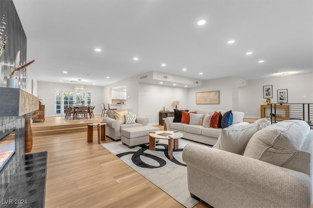 living area featuring recessed lighting, a fireplace, visible vents, baseboards, and light wood-style floors