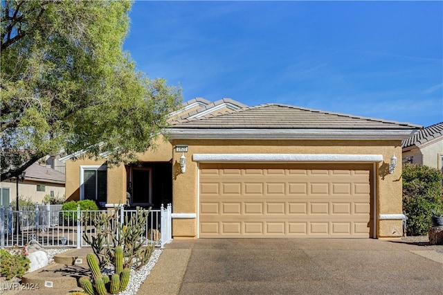 single story home featuring an attached garage, fence, a tile roof, driveway, and stucco siding