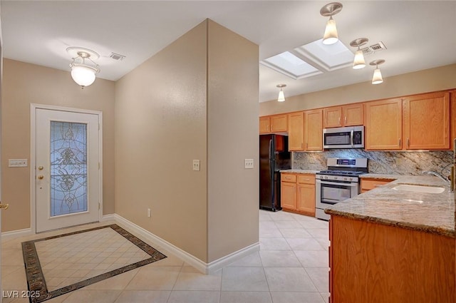 kitchen with stainless steel appliances, a skylight, a sink, baseboards, and backsplash