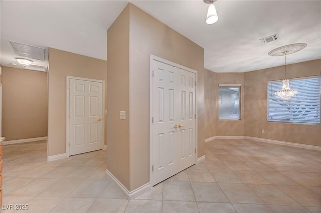 interior space featuring light tile patterned floors, baseboards, visible vents, and a chandelier