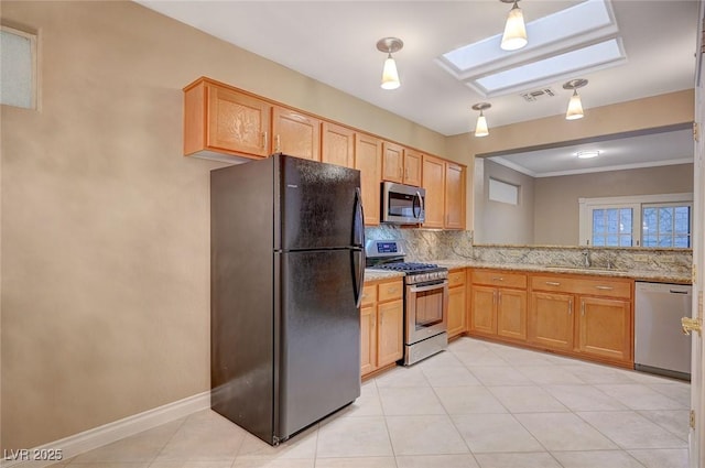 kitchen with a skylight, tasteful backsplash, appliances with stainless steel finishes, crown molding, and a sink