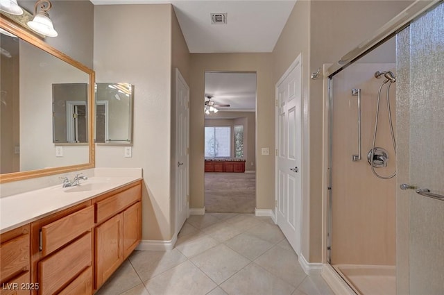 bathroom with a stall shower, tile patterned flooring, visible vents, and vanity