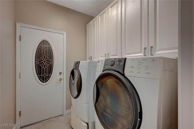 clothes washing area with washer and dryer, cabinet space, and light tile patterned floors