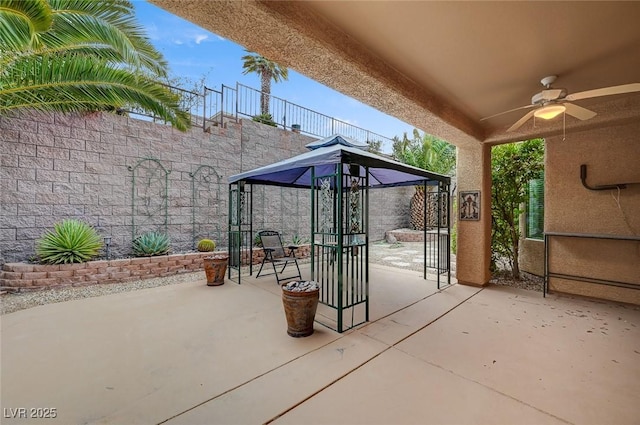 view of patio / terrace with ceiling fan and fence