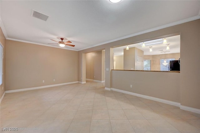 spare room with visible vents, crown molding, and baseboards