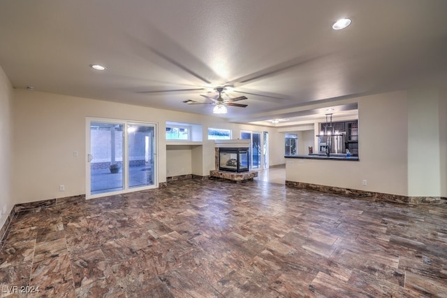 unfurnished living room featuring ceiling fan