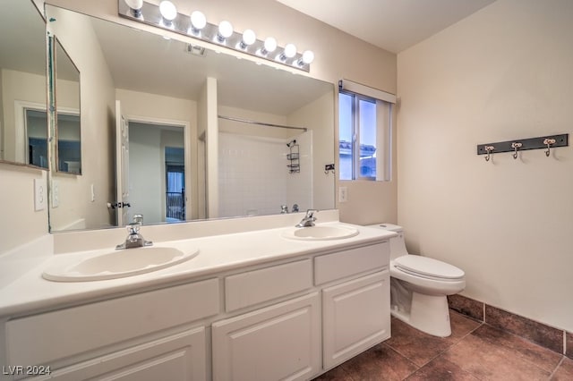 bathroom featuring a shower, tile patterned floors, vanity, and toilet