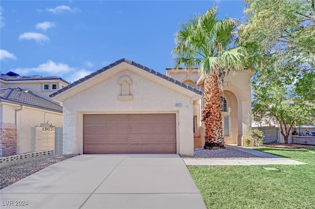 mediterranean / spanish-style home with a front lawn and a garage