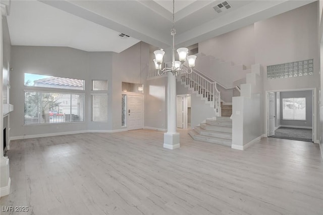 unfurnished living room with a notable chandelier, light hardwood / wood-style floors, and high vaulted ceiling