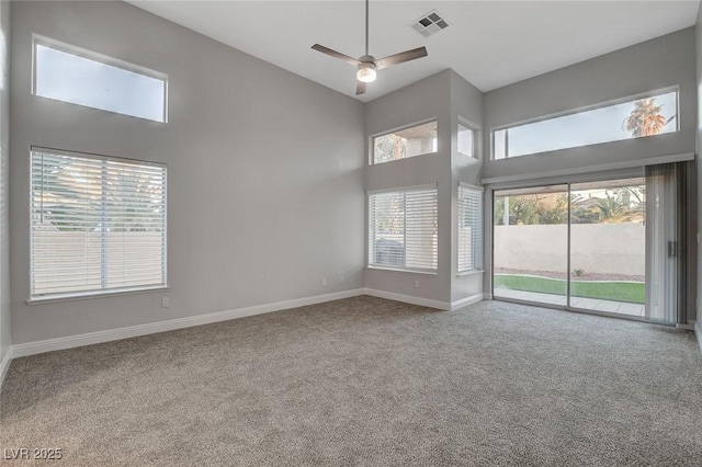 carpeted spare room featuring high vaulted ceiling and ceiling fan