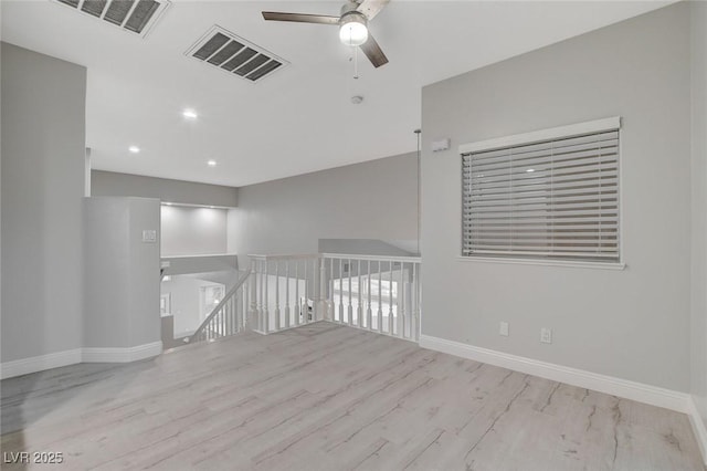 spare room with ceiling fan and light wood-type flooring