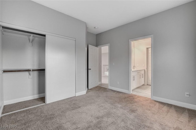 unfurnished bedroom with connected bathroom, light colored carpet, and a closet