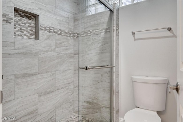 bathroom with a shower with door and toilet