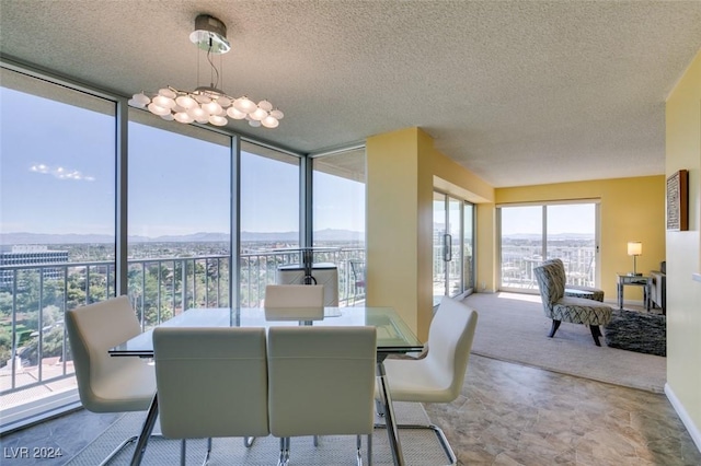 dining room featuring a textured ceiling and a wall of windows