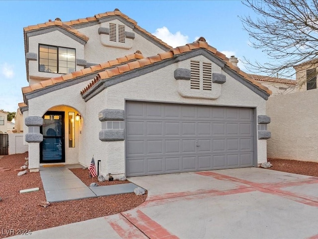 mediterranean / spanish-style house with a garage