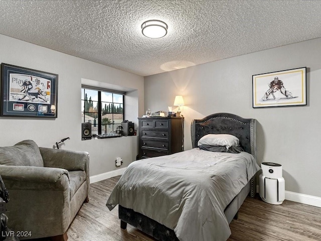 bedroom with hardwood / wood-style floors and a textured ceiling