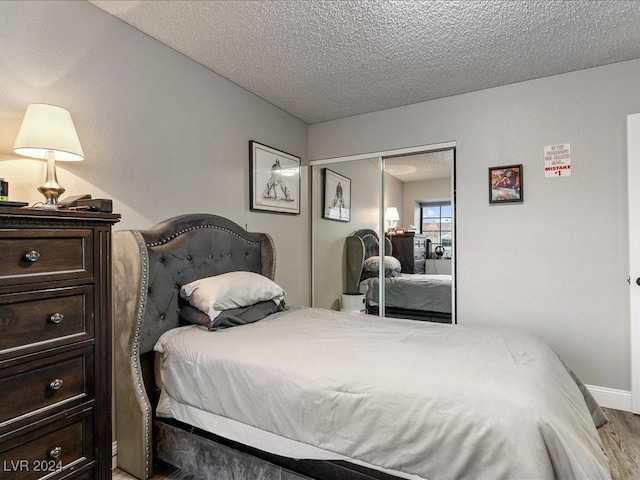 bedroom featuring a textured ceiling, a closet, and light wood-type flooring