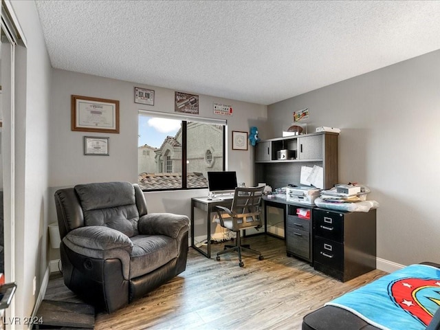 office area featuring a textured ceiling and light hardwood / wood-style flooring