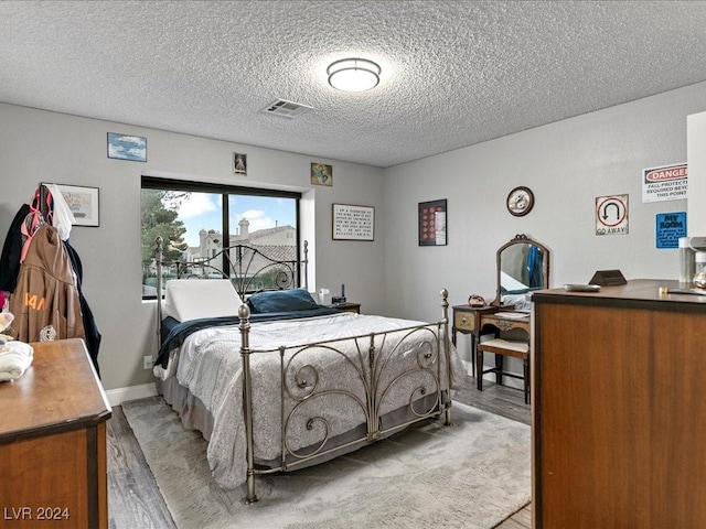 bedroom featuring a textured ceiling and light wood-type flooring