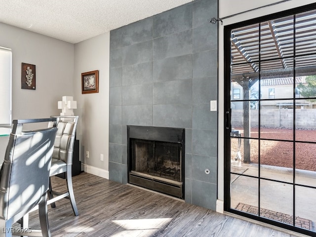 office area featuring a textured ceiling, a fireplace, and hardwood / wood-style flooring