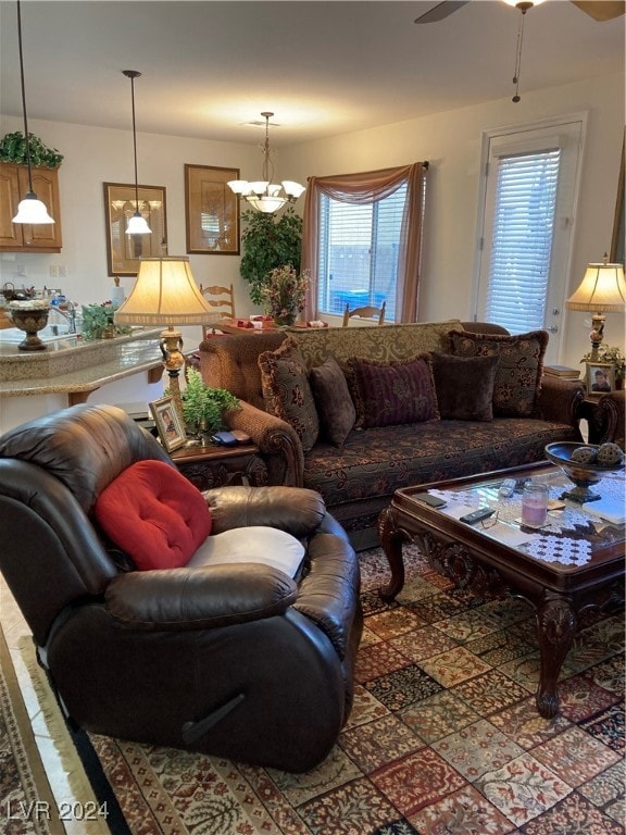 living room with ceiling fan with notable chandelier