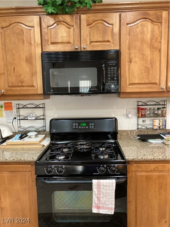 kitchen featuring black appliances and light stone counters