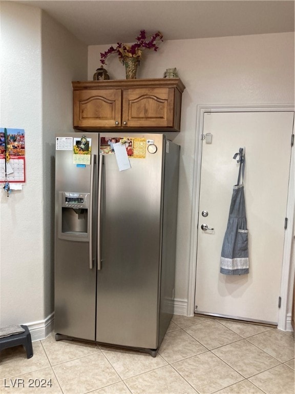 kitchen featuring stainless steel fridge with ice dispenser and light tile patterned floors