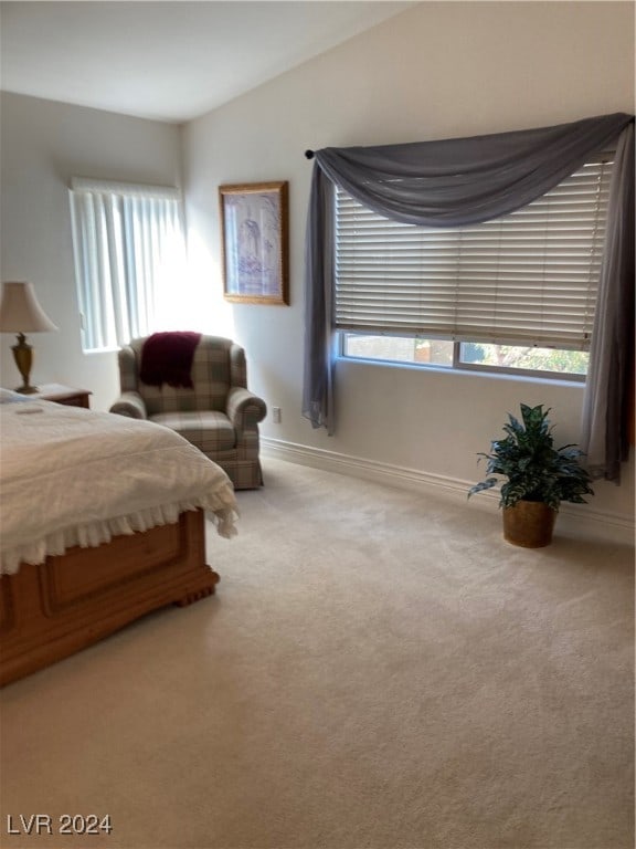 carpeted bedroom with lofted ceiling