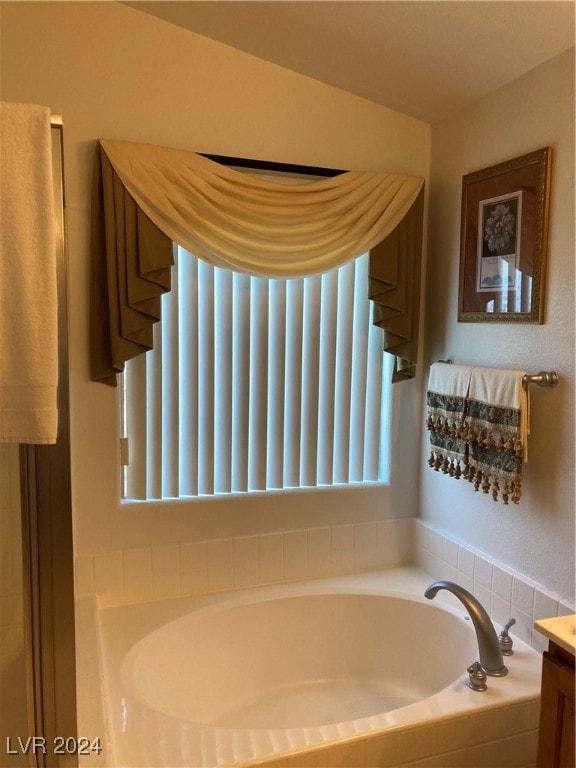 bathroom featuring a washtub and vanity