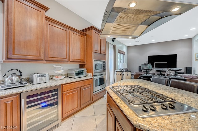 kitchen featuring beverage cooler, light tile patterned floors, light stone countertops, and stainless steel appliances