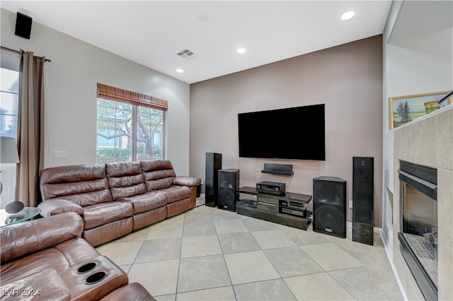 living room featuring a tile fireplace and light tile patterned flooring