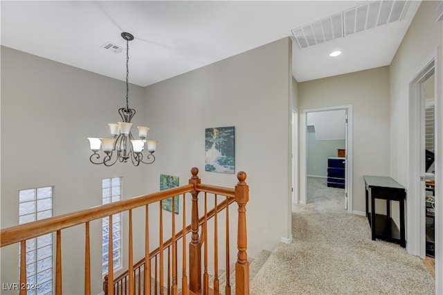 corridor featuring an inviting chandelier and carpet flooring