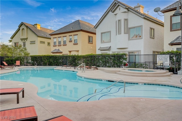 view of swimming pool with a community hot tub and a patio area