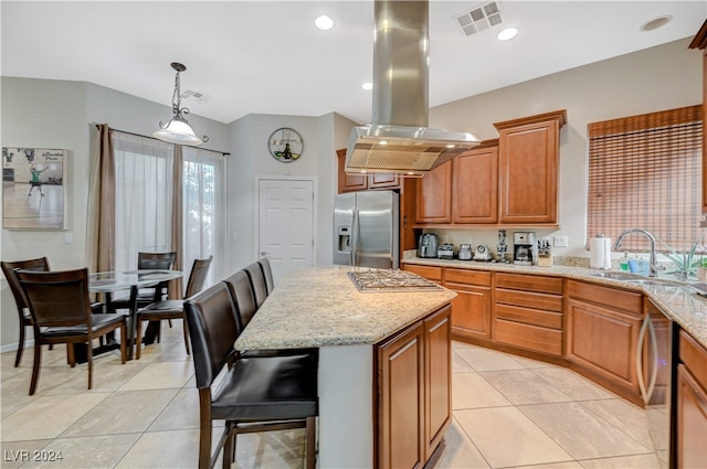 kitchen featuring a kitchen bar, hanging light fixtures, island exhaust hood, a kitchen island, and appliances with stainless steel finishes