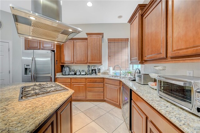 kitchen with sink, appliances with stainless steel finishes, light stone countertops, light tile patterned floors, and island range hood