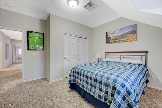 bedroom featuring carpet, vaulted ceiling, and a closet