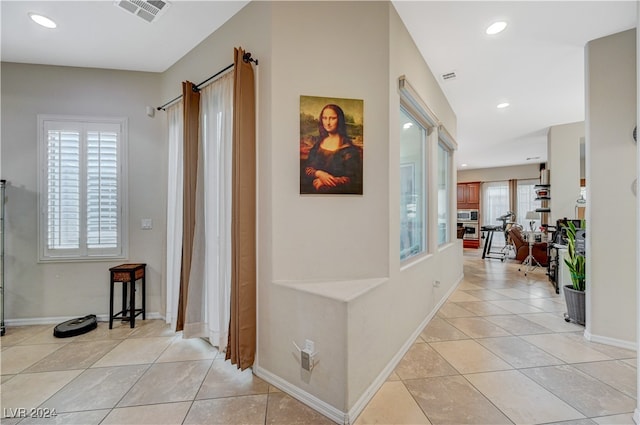 corridor featuring a healthy amount of sunlight and light tile patterned floors