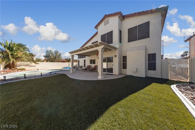 rear view of house with a yard, a pergola, a fenced in pool, and a patio