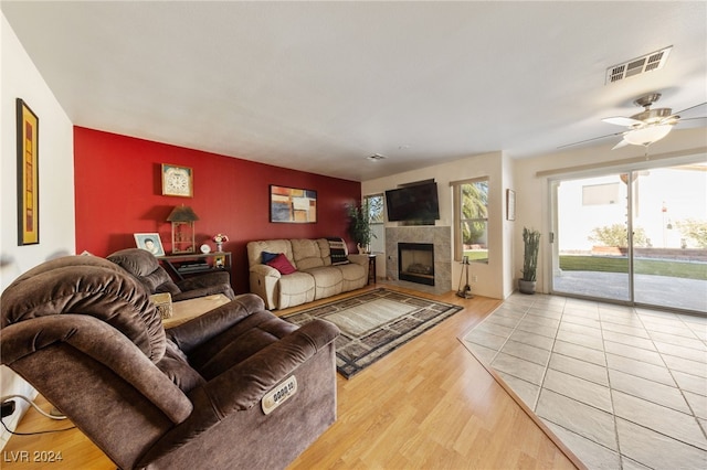 living room featuring a fireplace, hardwood / wood-style flooring, and ceiling fan