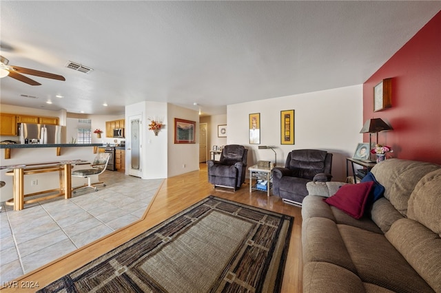 living room with light hardwood / wood-style floors and ceiling fan