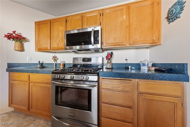 kitchen with light tile patterned floors and appliances with stainless steel finishes