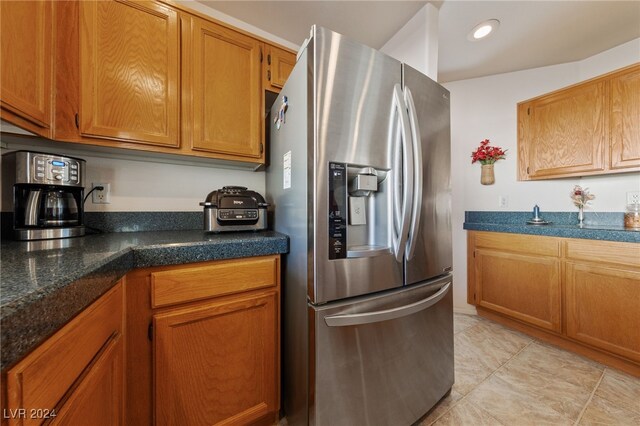 kitchen featuring light tile patterned floors and stainless steel refrigerator with ice dispenser