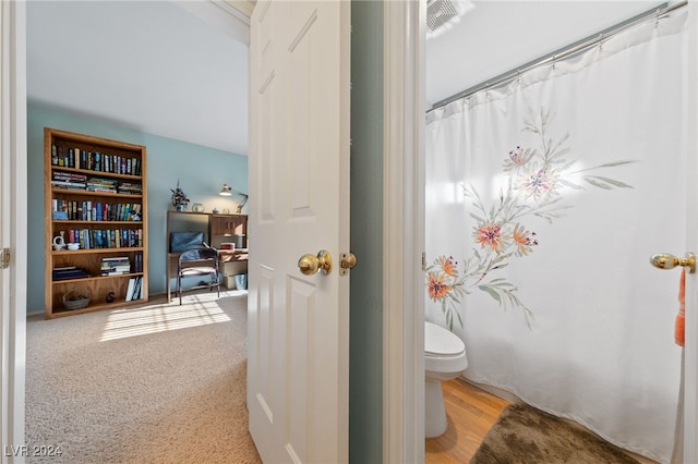 bathroom featuring hardwood / wood-style floors, toilet, and curtained shower