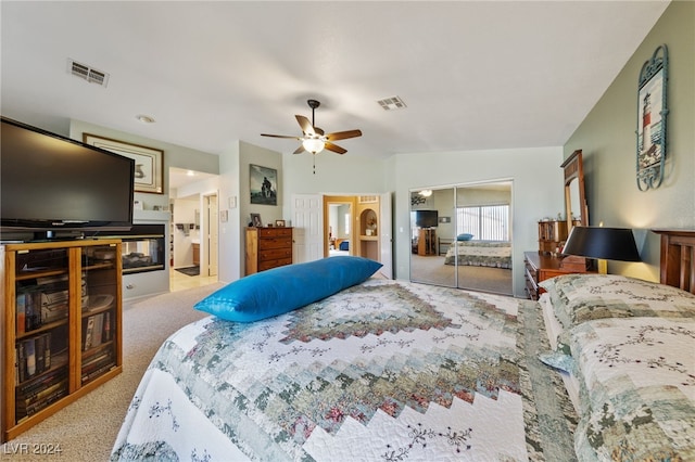 carpeted bedroom with ceiling fan, a closet, and vaulted ceiling