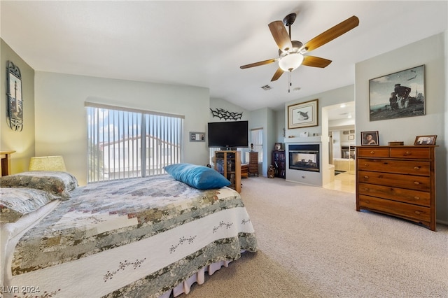 bedroom featuring ceiling fan, carpet, ensuite bathroom, and vaulted ceiling