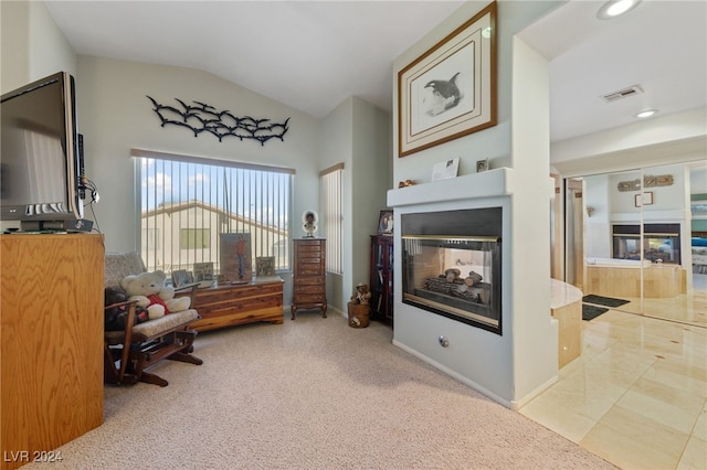 interior space with a multi sided fireplace, light carpet, and vaulted ceiling