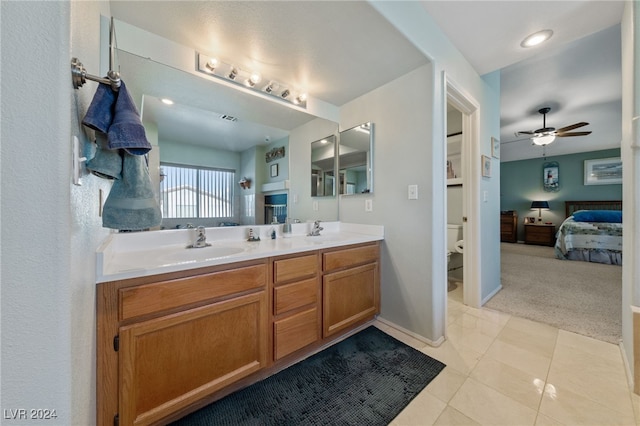 bathroom featuring vanity, toilet, and ceiling fan