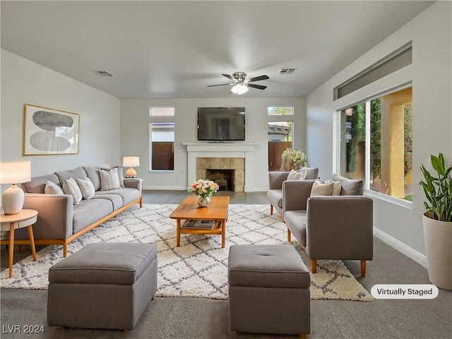 living room with carpet, ceiling fan, and a tile fireplace