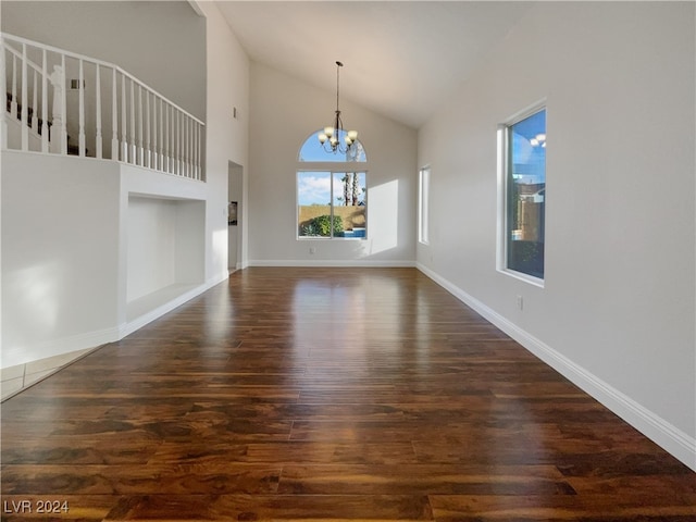 interior space with high vaulted ceiling, an inviting chandelier, and dark hardwood / wood-style floors