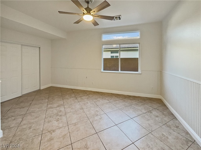 unfurnished bedroom featuring light tile patterned floors, ceiling fan, and a closet